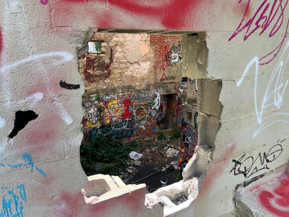 Hole in the wall reveals the graffiti interior