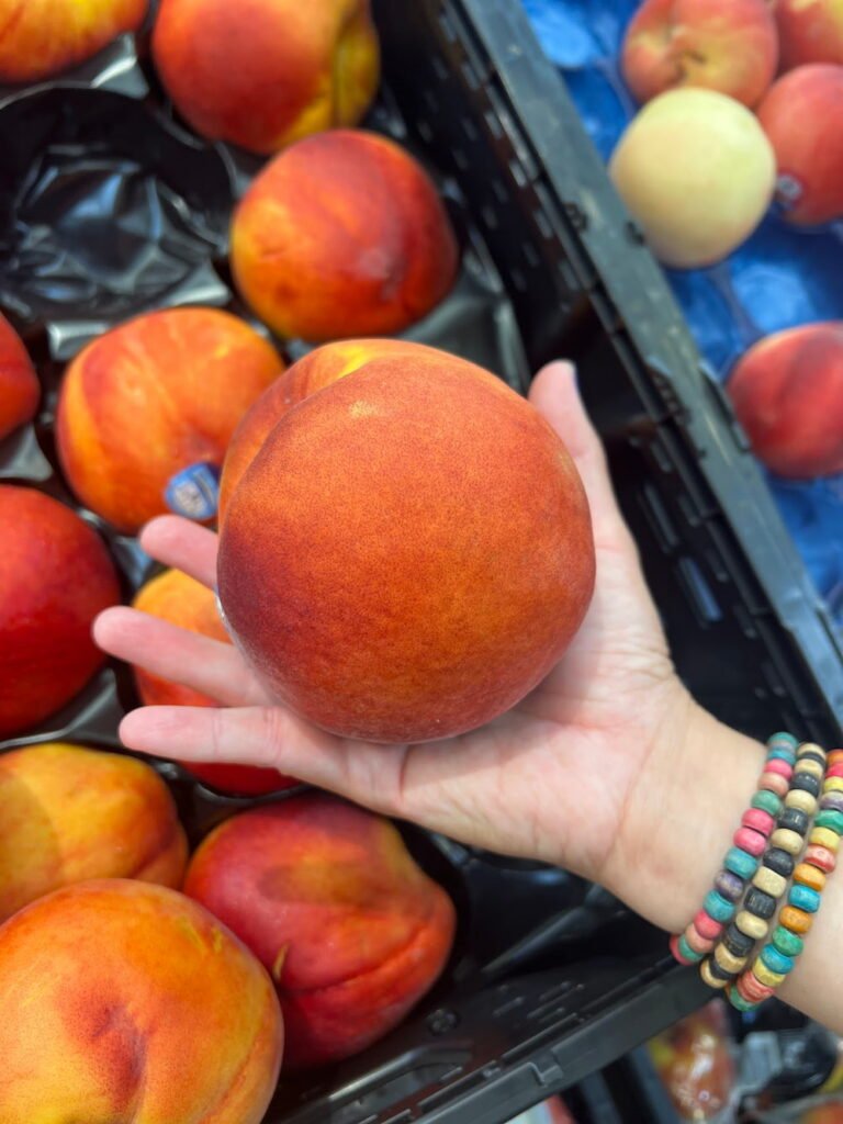 Lisette holding a giant peach