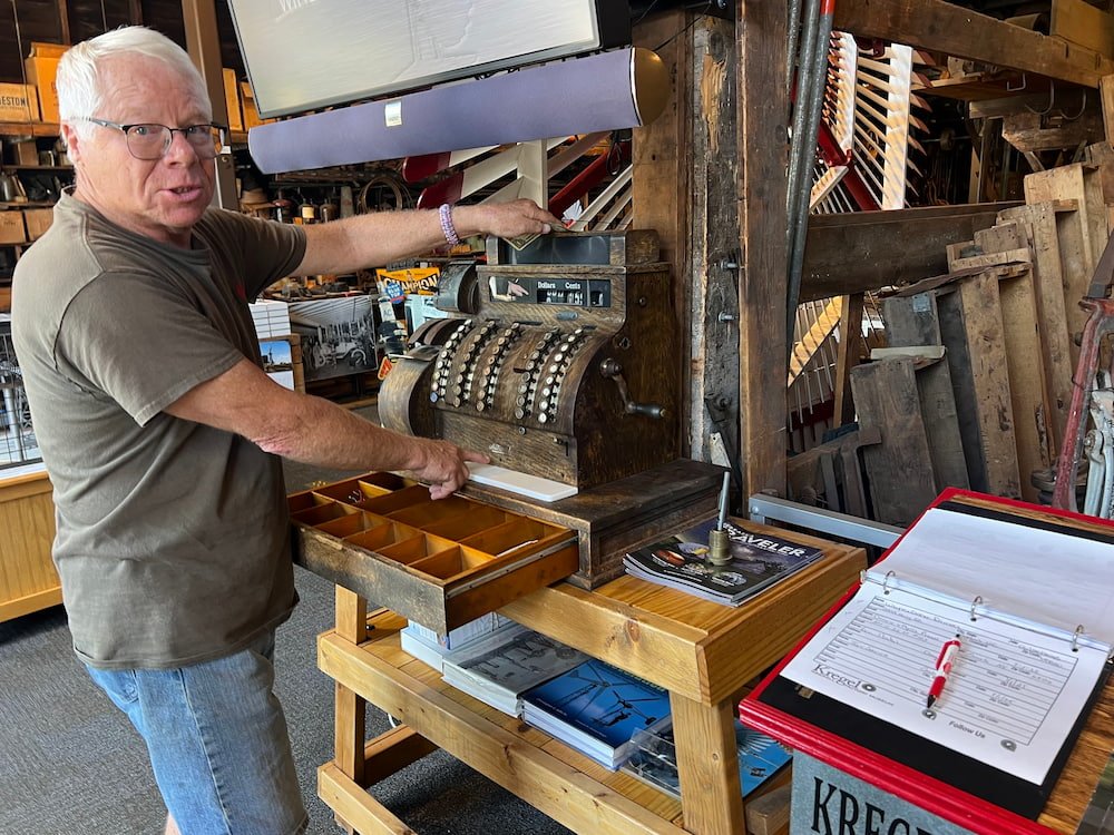 Our docent using the old cash register to take our cash