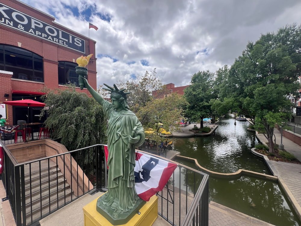 Small Statue of Liberty replica with the canal in the background