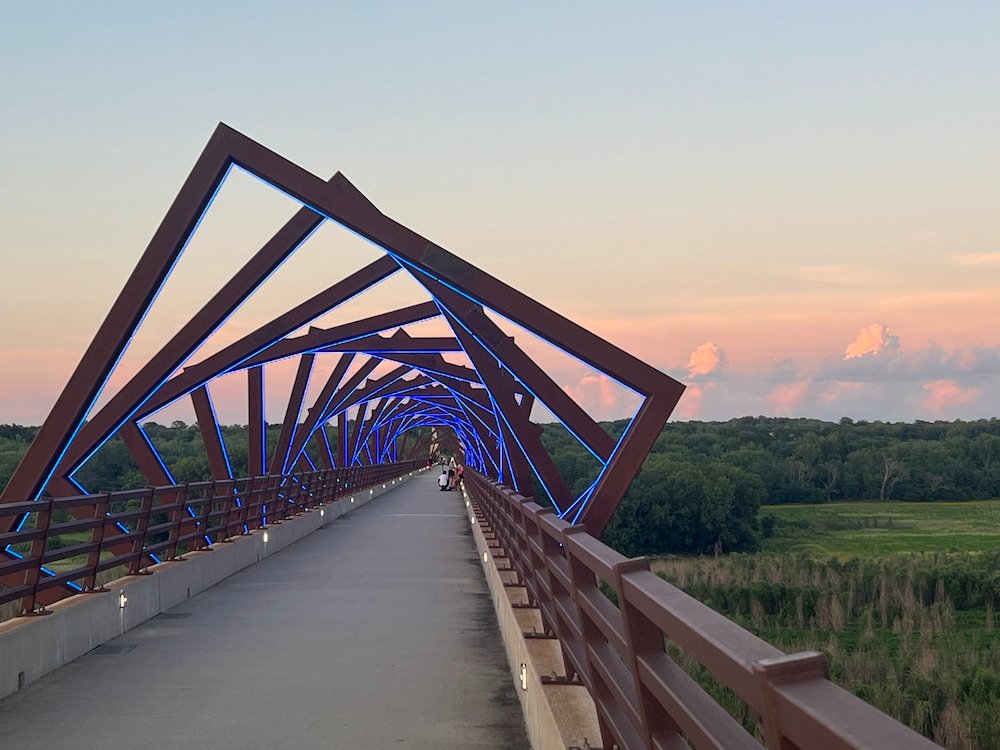 The bridge lit up with the sun setting on the clouds