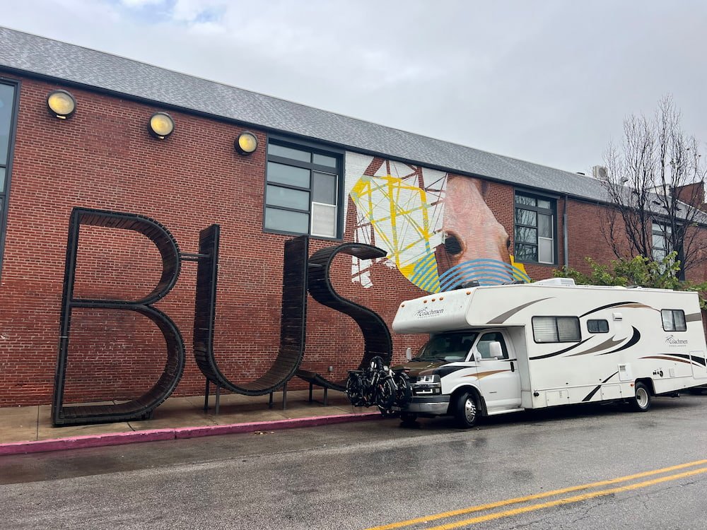 Our RV next to the BUS sign