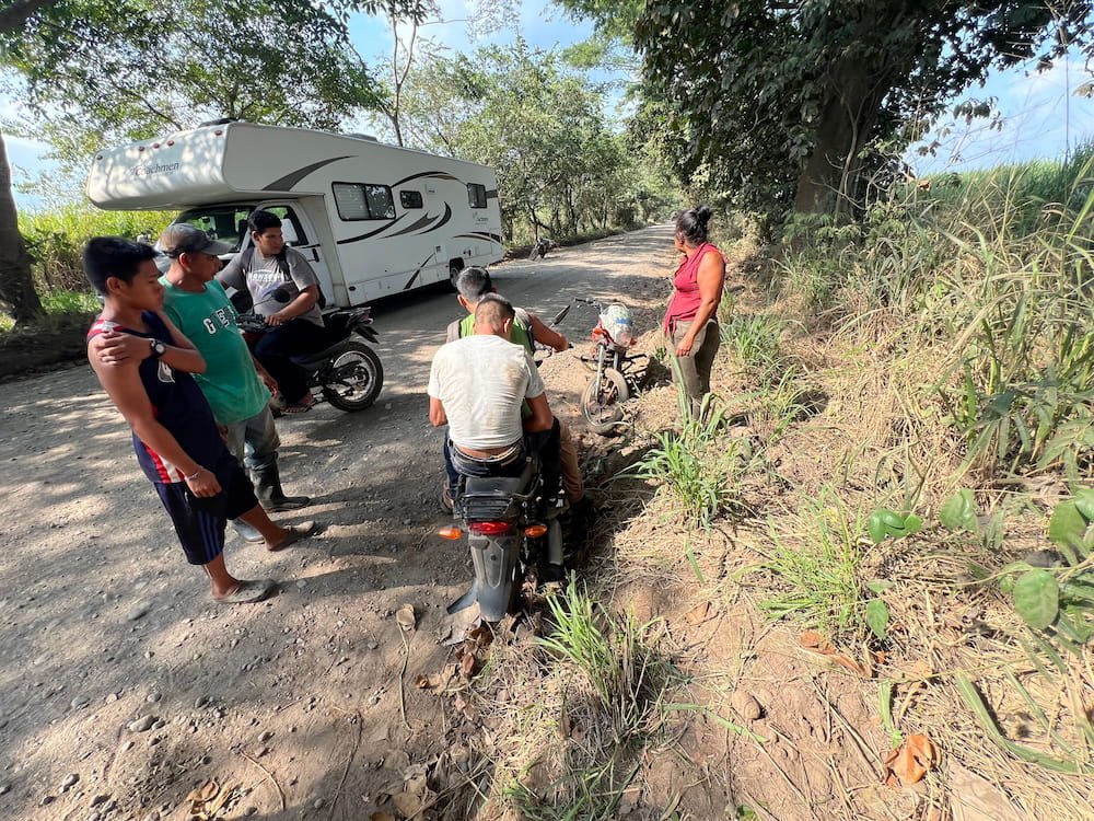 The motorbike guy getting a lift on the back